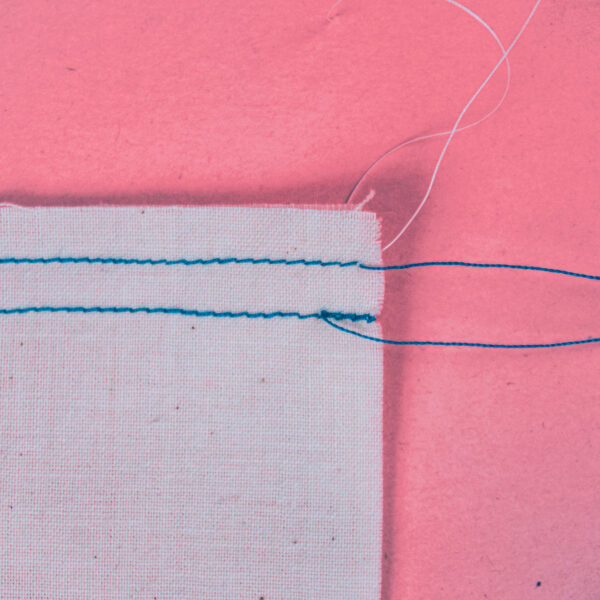 A back stitch shown along side a straight stitch.