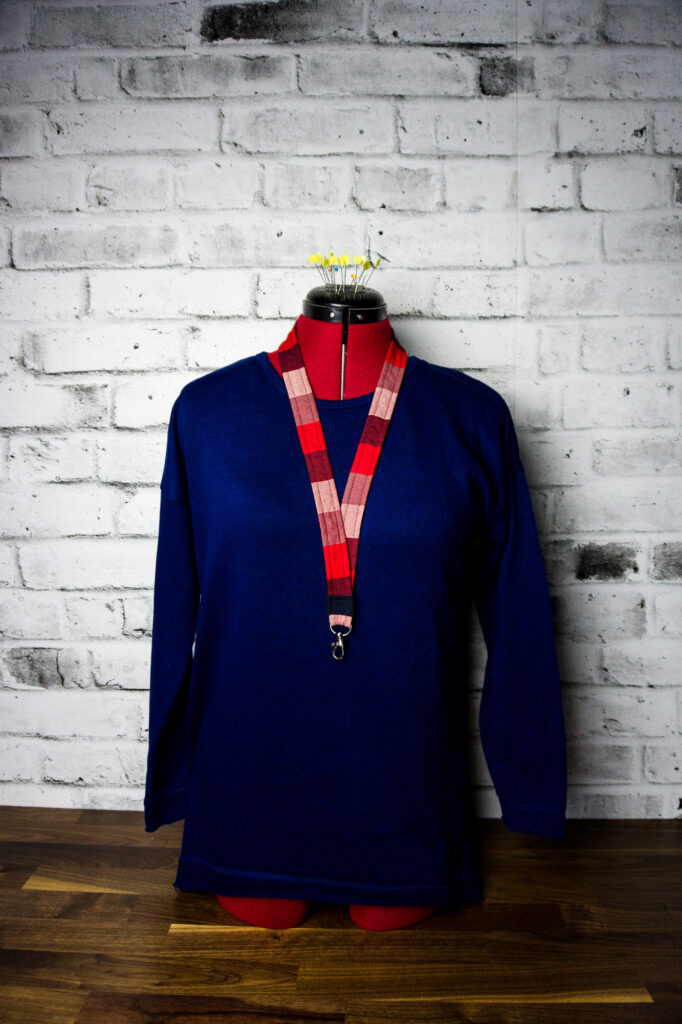 A dress manikin in a royal blue sweater wearing a plaid diy lanyard.
